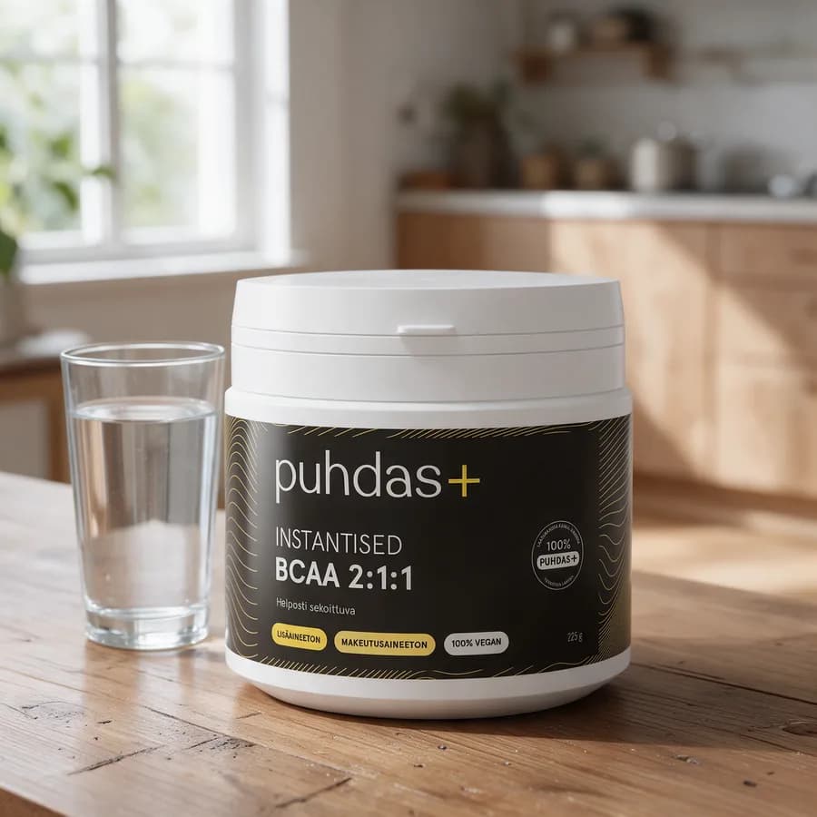 Valkoinen Puhdas+ Instantised BCAA 2:1:1 -purkki mustalla etiketillä puisella keittiön pöydällä vesilasin vieressä