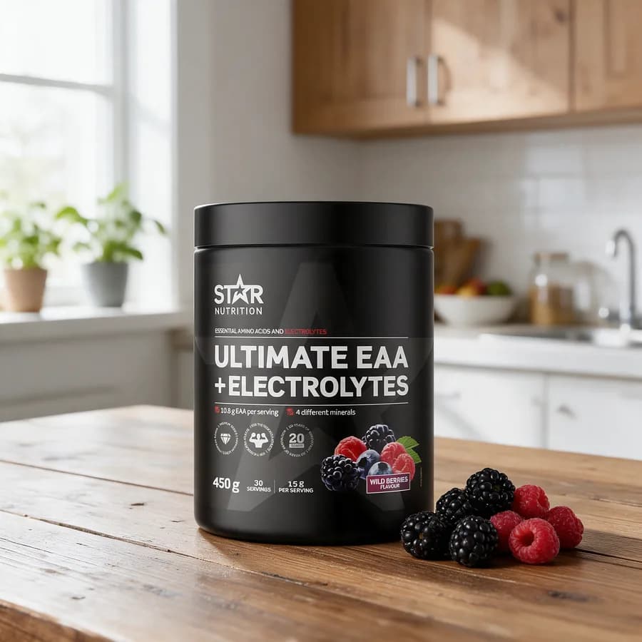 Musta Star Nutrition Ultimate EAA + Electrolytes -purkki marjakuvalla puisella keittiön pöydällä